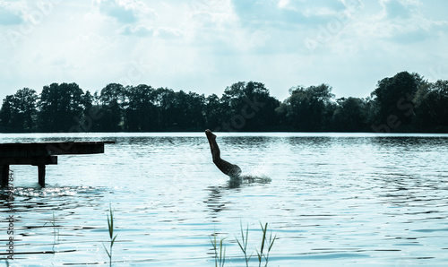 woman jumping into the lake © wideeyes