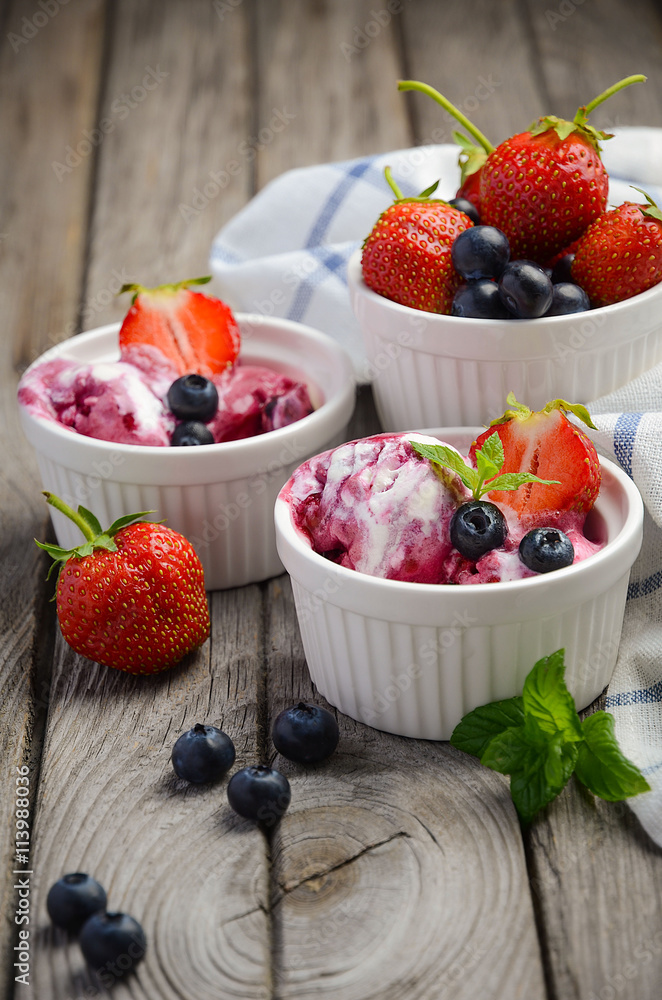 Ice cream with blueberries and strawberries in white bowl on rustic wooden background, selective focus, copy space Ice cream with blueberries and strawberries in white bowl on rustic wooden background, selective focus, copy space