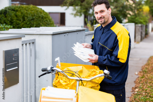 Postman delivering letters to mailbox of recipient