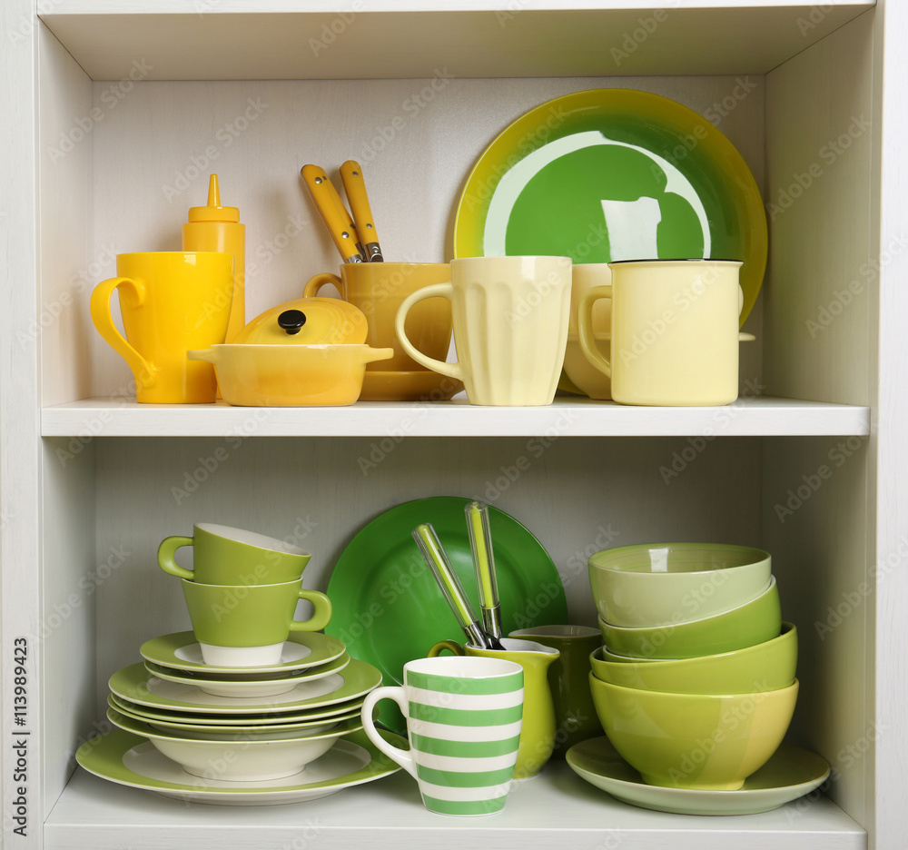 Fototapeta premium Tableware on shelves in the kitchen cupboard