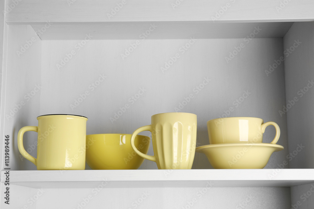Tableware on shelf in the kitchen cupboard Tableware on shelf in the kitchen cupboard