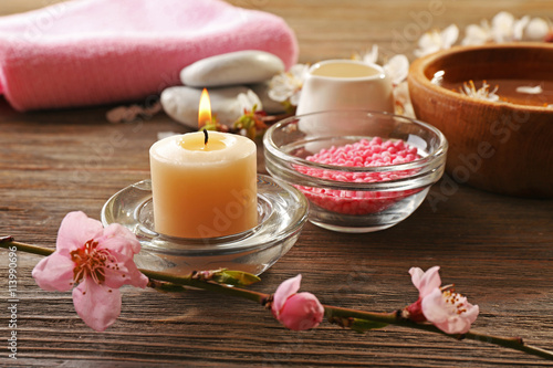 Spa composition with blooming branches on wooden table