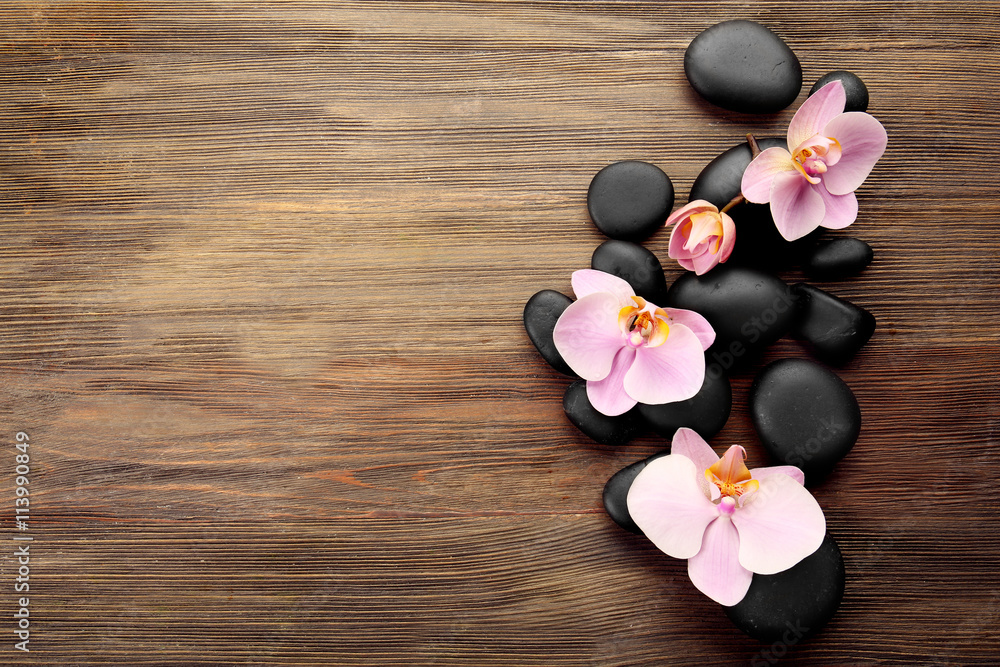 Spa stones and orchid flowers on wooden background Spa stones and orchid flowers on wooden background