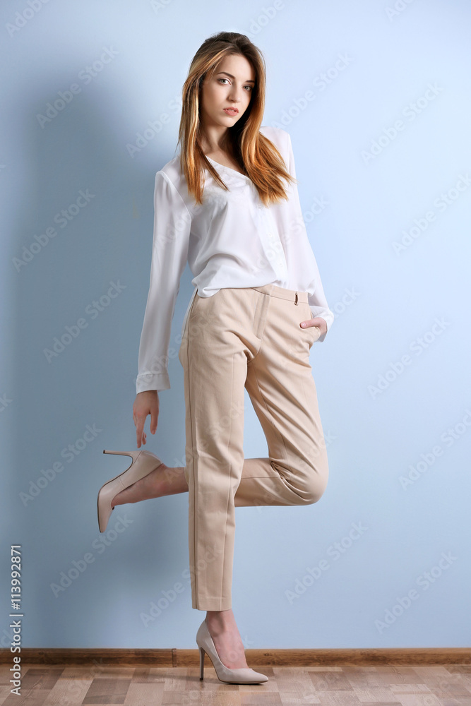 Beautiful Stylish Young Girl Wearing Trendy White Shirt Beige Trousers  Stock Photo by ©alextorb 200359200