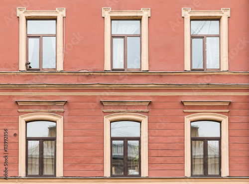 Several windows in a row on facade of urban apartment building front view  St. Petersburg  Russia.