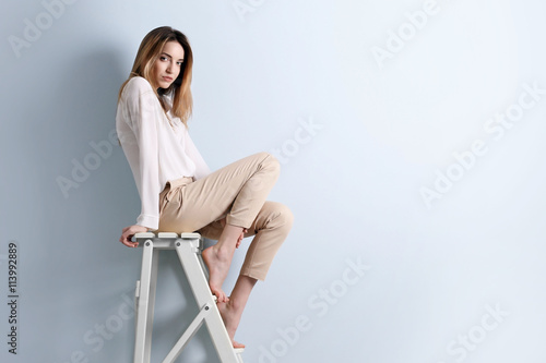 Beautiful young woman sitti...