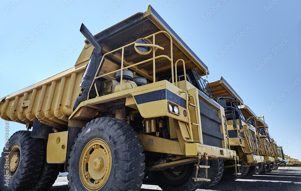 Heavy equipment row industrial mining dump trucks Heavy equipment row industrial mining dump trucks