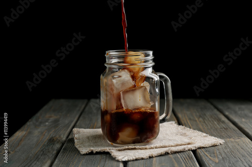 Jar of iced coffee on wooden table