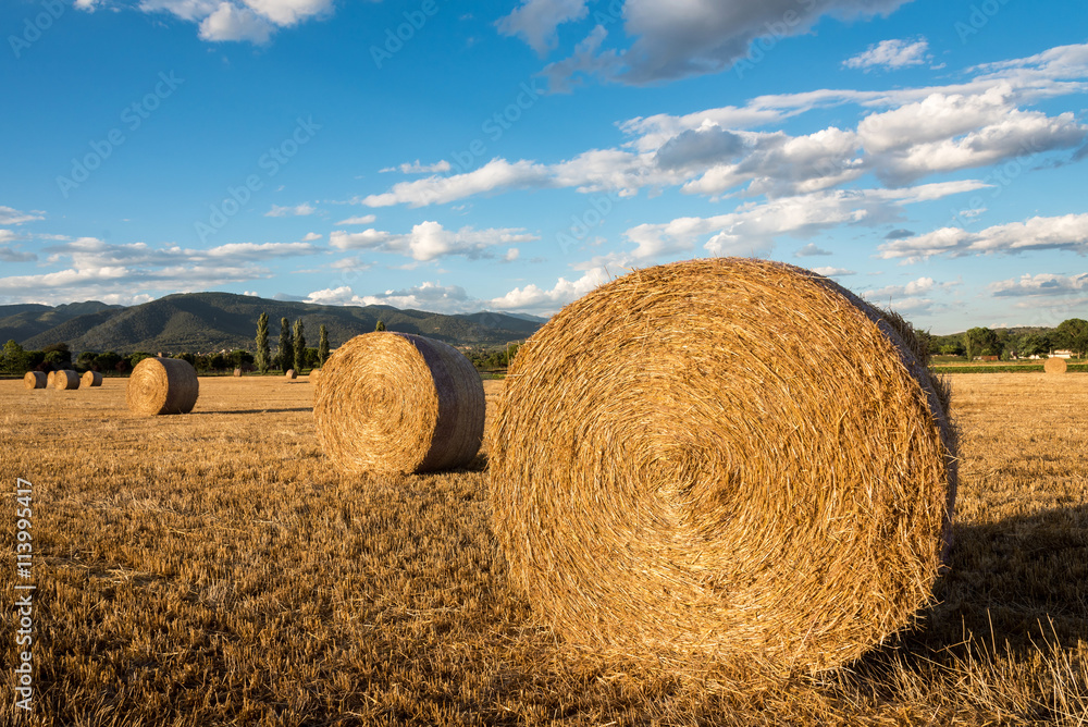 Straw bales below a cloudy sky