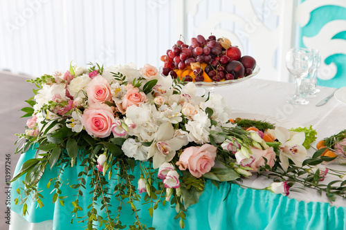  декоррация из живых цветов и ваза с фруктами на столе