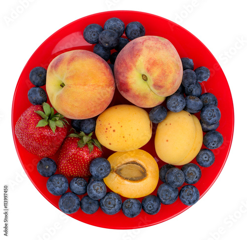  Fresh blueberry  strawberry  peach and apricot on a red plate