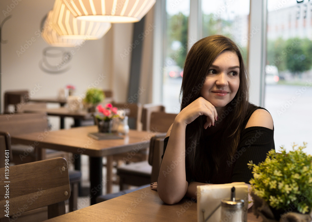 The girl at the table in a cafe The girl at the table in a cafe