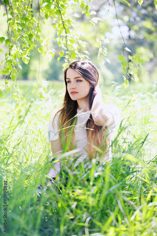 Pensive woman in the grass