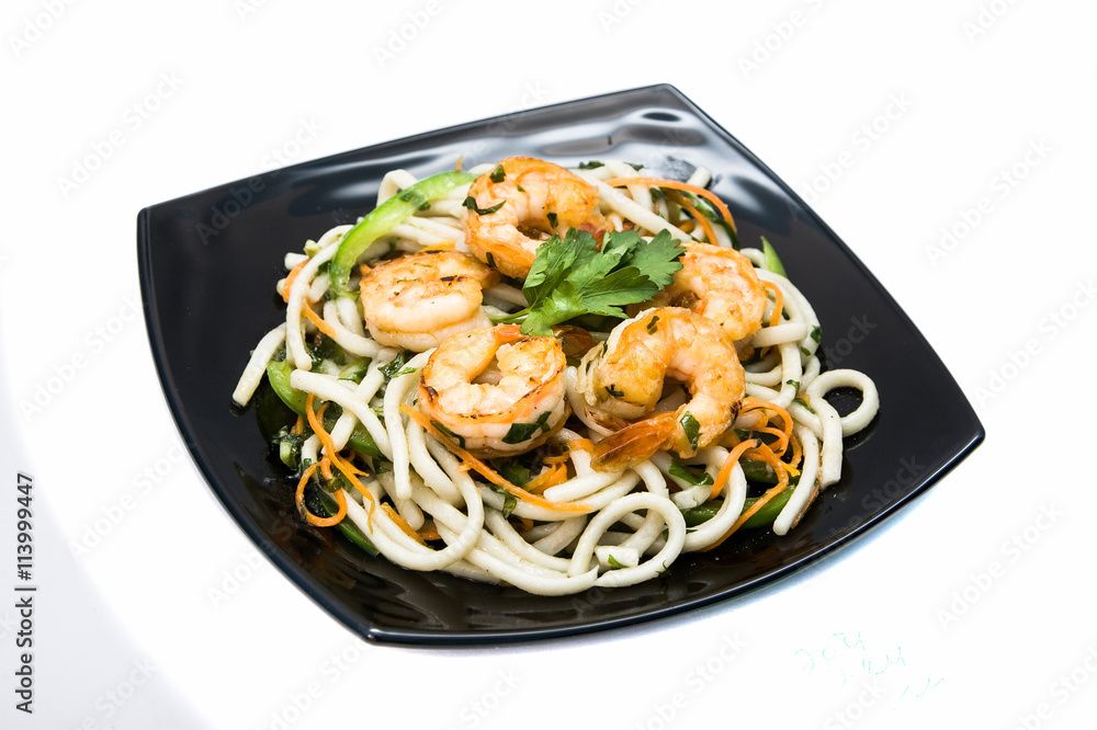 Asian noodles with shrimp. On the black plate. Isolated on white background