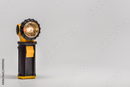Black and yellow flashlight on gray background