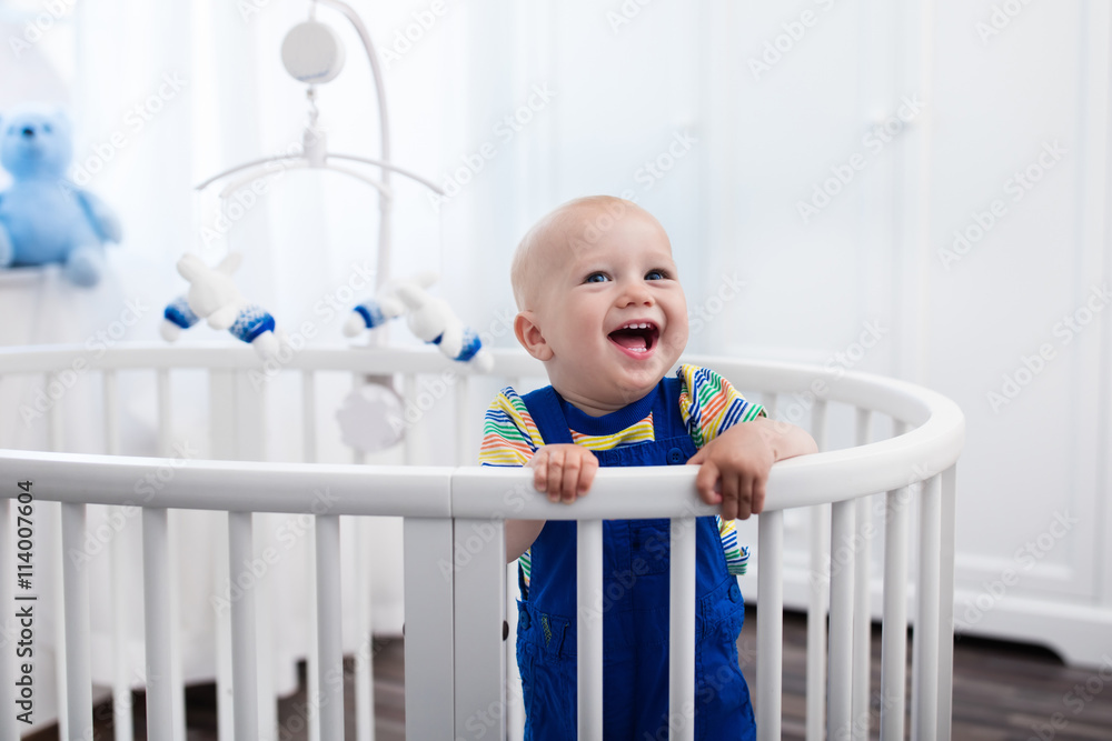 Baby boy standing in bed