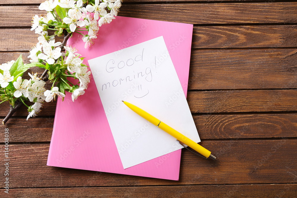 Blooming branch and note on wooden background Blooming branch and note on wooden background