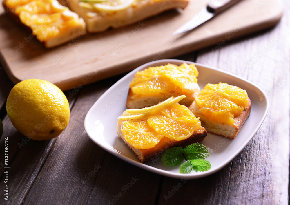 Plate with delicious citrus cake on wooden background Plate with delicious citrus cake on wooden background