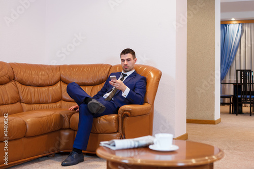 Young businessman drinking coffee and talking on the phone