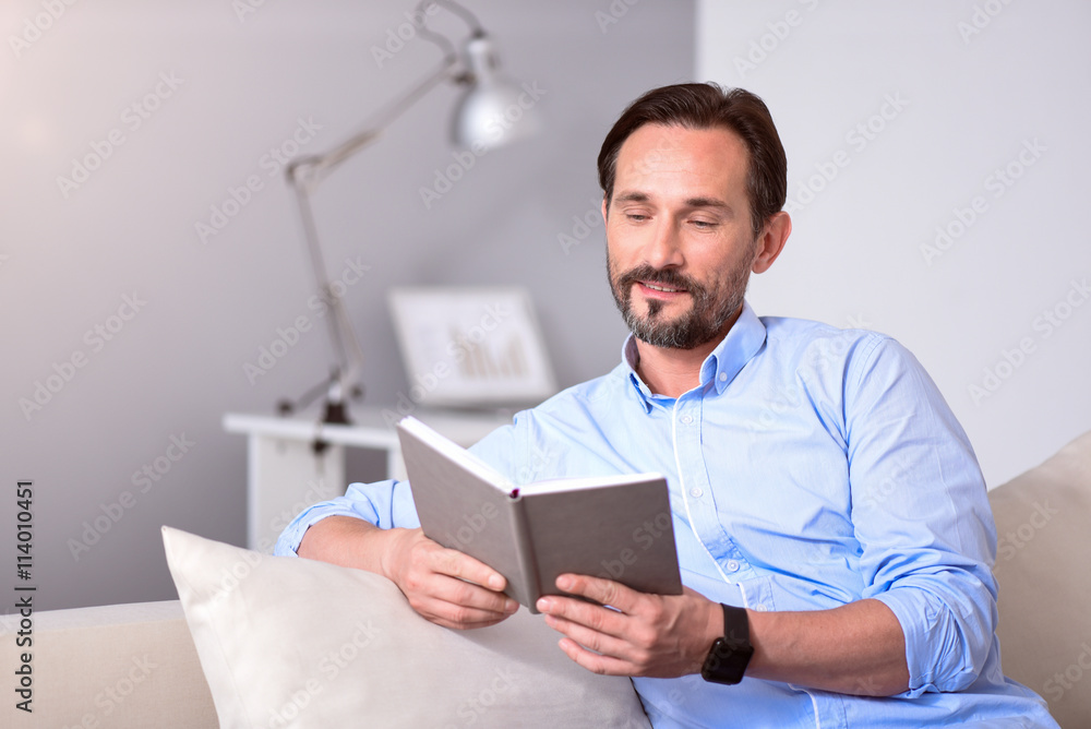 Man looking at the book while sitting Man looking at the book while sitting
