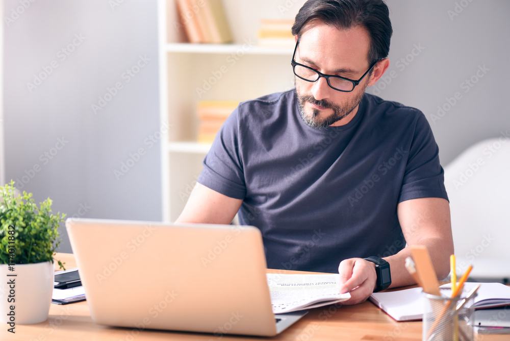 Man holding newspaper in front of laptop Man holding newspaper in front of laptop