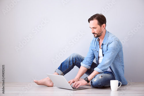 Cuadro en lienzo Man using laptop on grey background