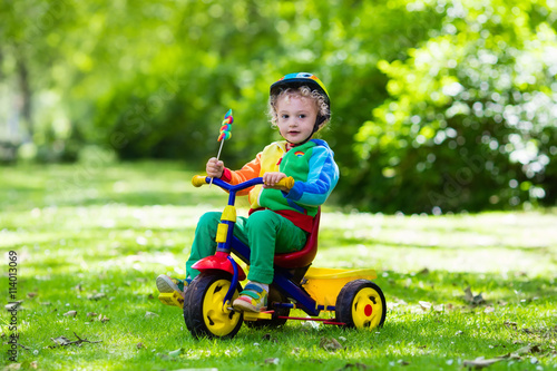 Obraz na plátně Little boy on colorful tricycle