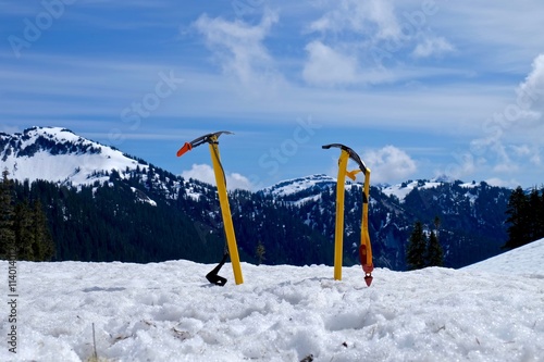 Couple of ice axes in snow against mountains. Ruth Mountain, North Cascades National Park, Washington, USA.  photo