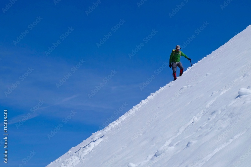 Man climber on snow covered steep mountain slope. Mount Baker wilderness, North Cascades National Park, Washington, USA. 