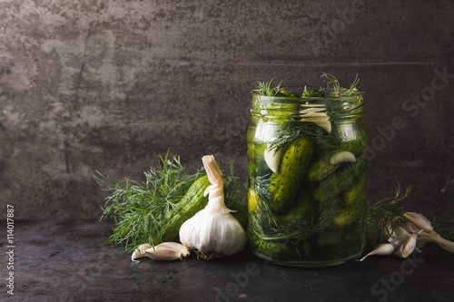 Glass jar of pickles with dill and garlic photo