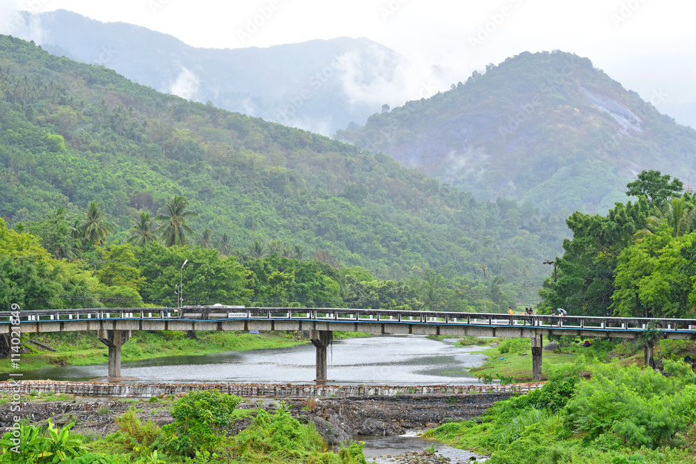 The bridge across the mountain is covered with clouds and rain in the rainy season.