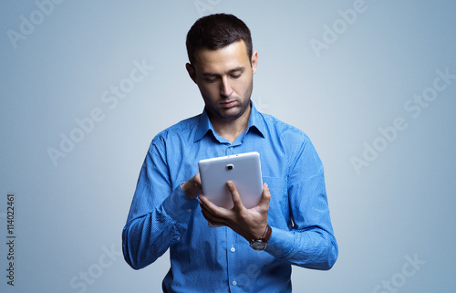 Handsome young man using a digital tablet in her hands. Internet technologies. Business negotiations. Business lifestyle. Digital communication