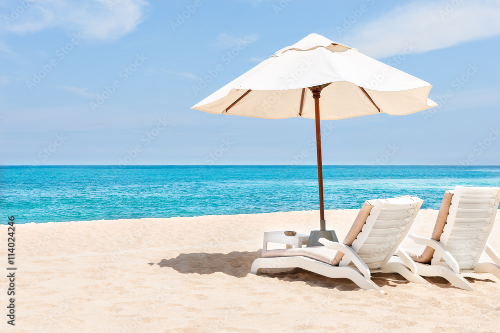 Beach chairs and umbrellas on the sand near water side