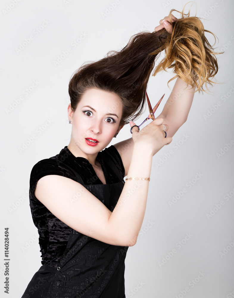 Fototapeta premium female Hairdresser trying to cut your own hair with scissors