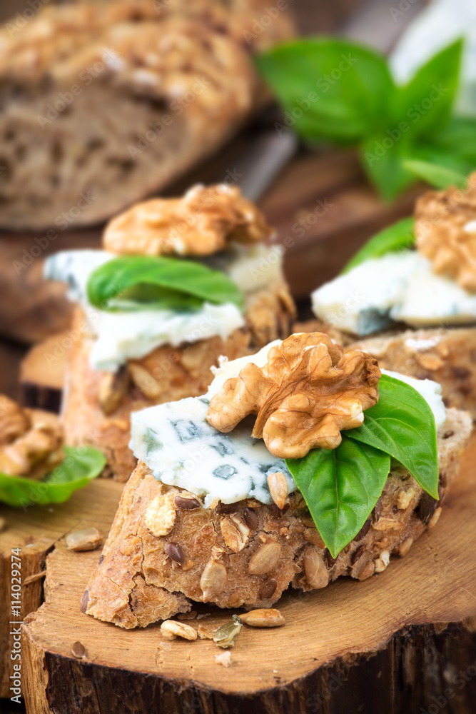 Roquefort and walnut canape decorated with leaves of fresh basil
