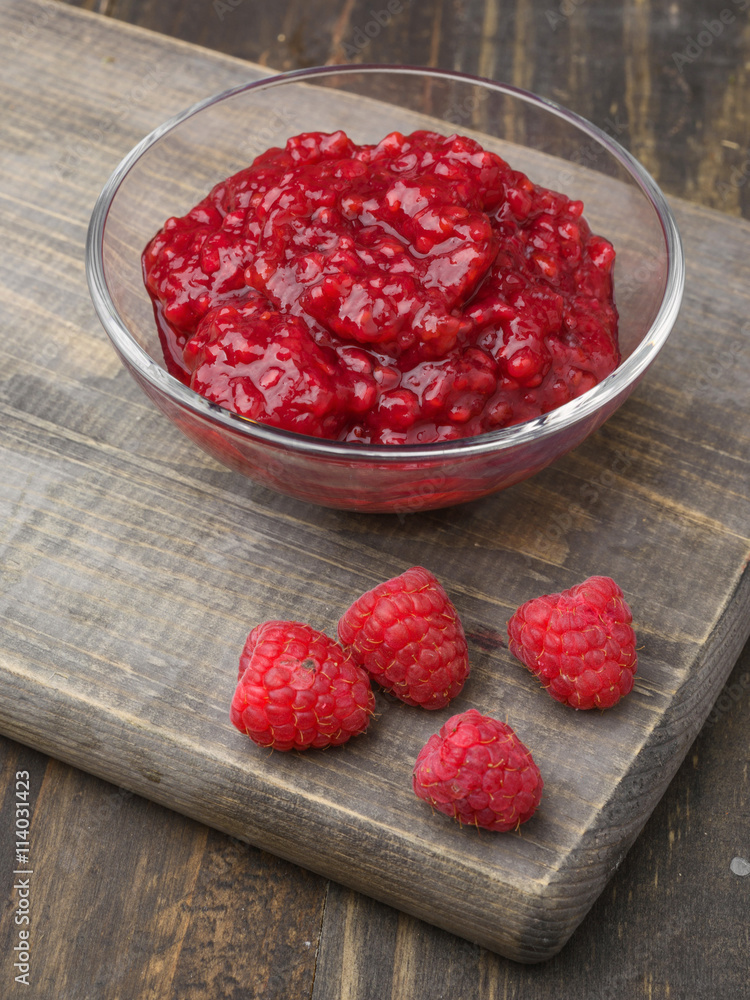 jam bowl with ripe raspberries on wood jam bowl with ripe raspberries on wood
