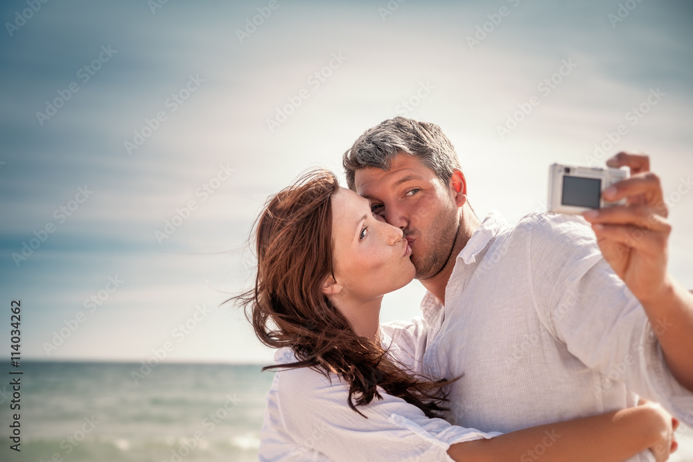 Obraz premium happy couple taking selfie on beach