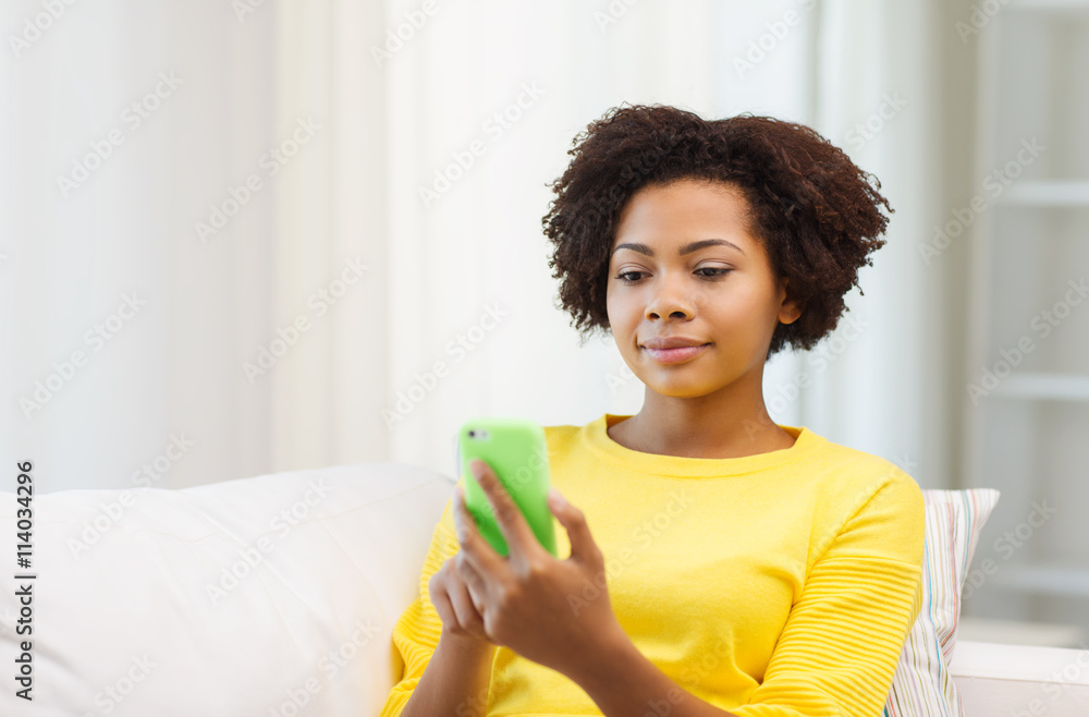 happy african woman with smartphone at home