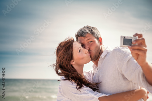 happy couple taking selfie on beach © detailblick-foto