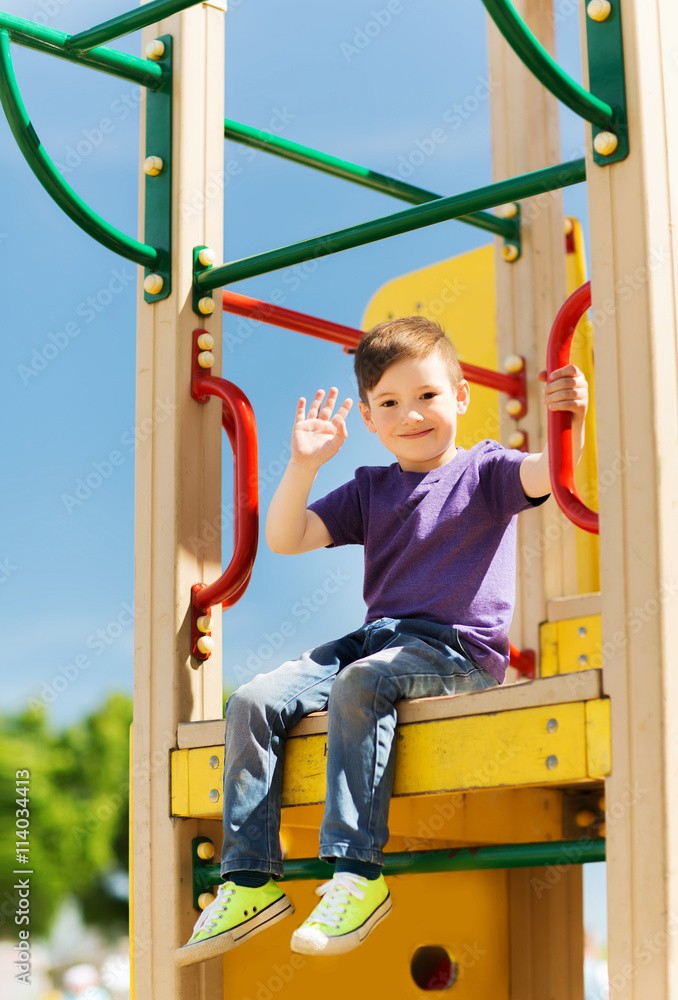 Fototapeta premium happy little boy climbing on children playground