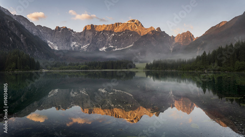 Panorama jeziora górskiego,góry oświetlone wschodzącym słońcem