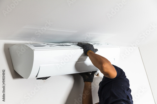 Foto Technician air conditioning installs the new air conditioner