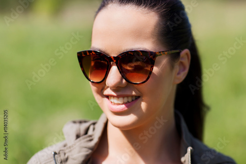 face of happy young woman in sunglasses outdoors