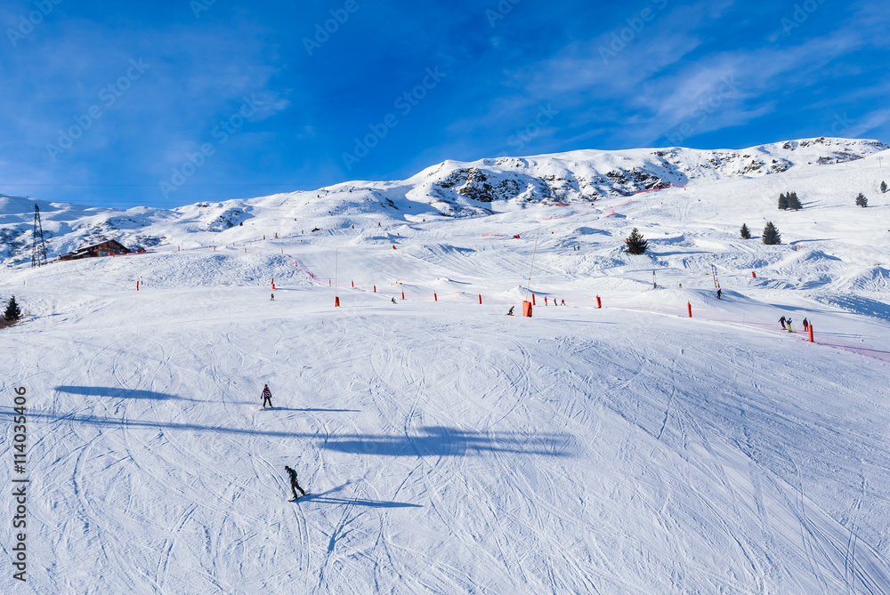 Unidentified skiers enjoy skiing at the slope in the  Alps. Ski