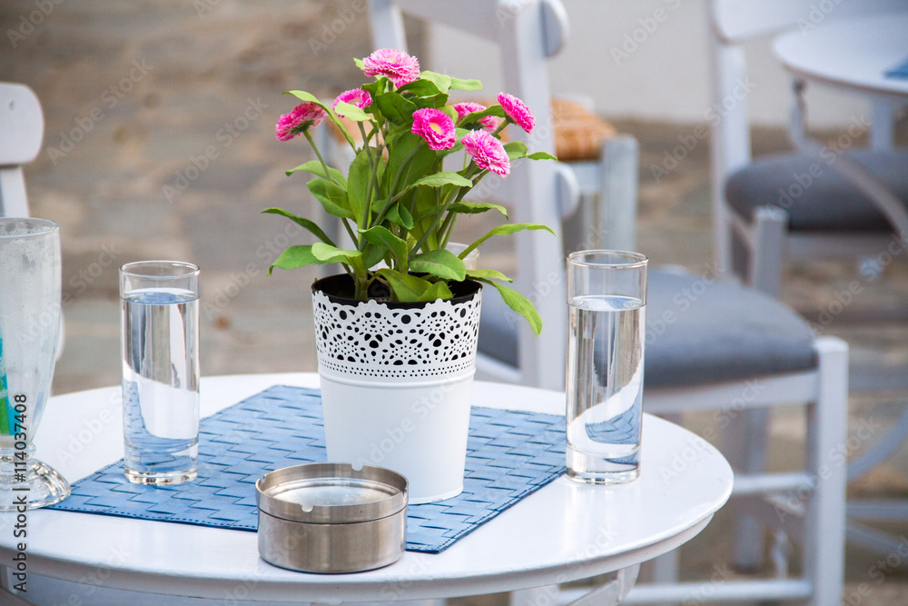 Table at a cafe with flowers and water Table at a cafe with flowers and water