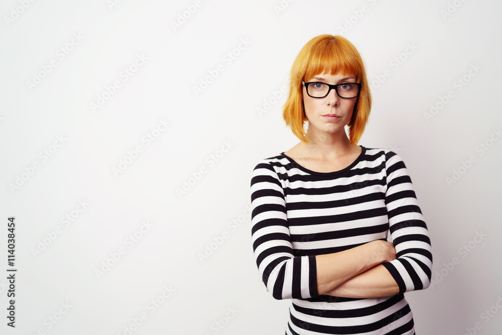 Fototapeta premium selbstbewusste junge frau mit verschränkten armen und ernstem blick