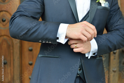 Hands of wedding groom in a elengant suit getting ready. Details
