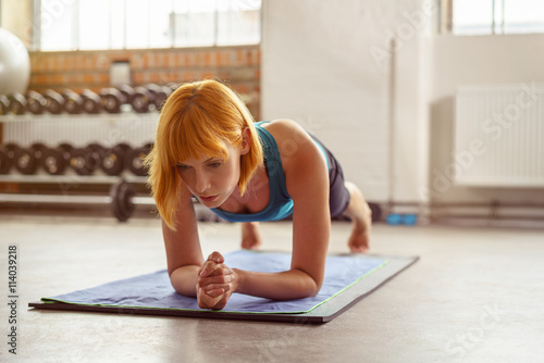 Tableau sur toile frau macht übungen im fitness-studio auf einer matte