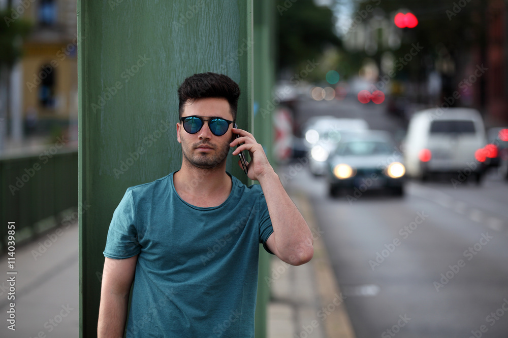 Handsome young man talking on phone on the street Handsome young man talking on phone on the street