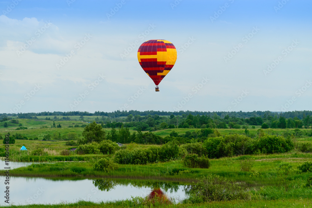 Fototapeta premium air balloon flight over the trees on a background of clouds